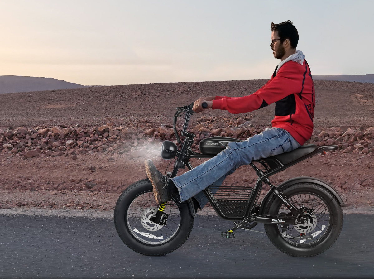 A rider in a red hoodie on the Pilot G/S, crossing a desert road at dusk